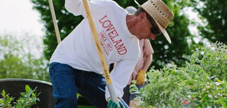 A volunteer uses a shovel to plant a tree at the Audubon Loveland Visitor Center.